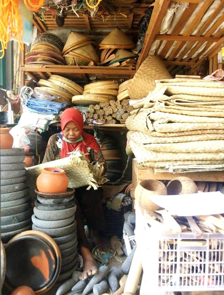 Seorang pedagang alat rumah tangga tradisional sedang menunggui dagangannya sambil menganyam di pasar tradisional Desa Gabus, Kecamatan Gabus, Pati, Jawa tengah, Sabtu (7/9/2019). Hingga saat ini penjualan alat-alat rumah tangga tradisional berbahan baku bamboo, tanah liat dan kayu masih bertahan.