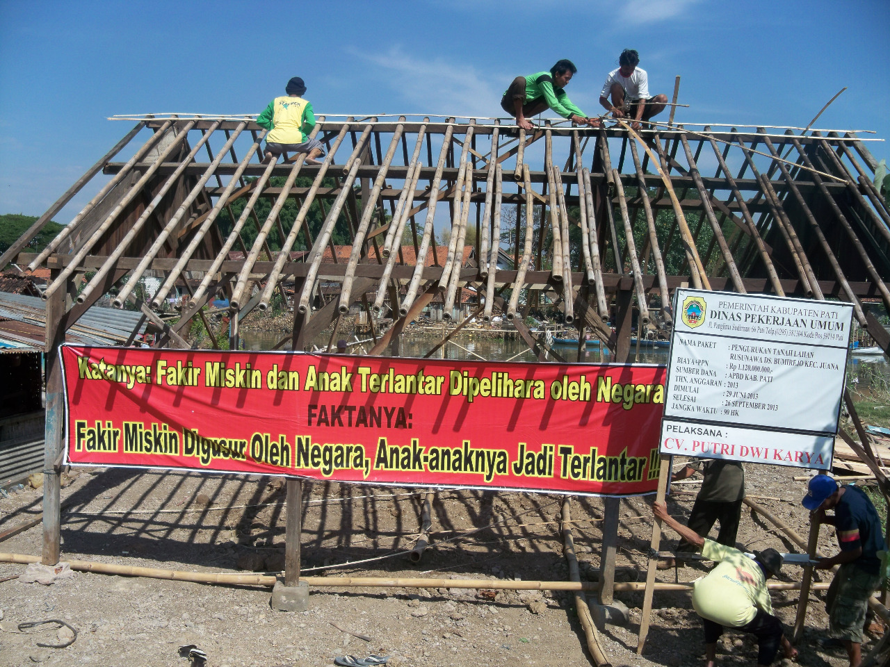 Sejumlah warga bergotong royong membangun rumah warga Desa Bumirejo Kecamatan Jakenan Kabupaten Pati yang berada di tepi Sungai Juwana (16/10/2013). Rumah warga yang di bangun merupakan rumah yang digusur pemerintah karena terkena proyek pembangunan rumah susun. Selain bergotong royong mereka juga membentangkan spanduk bernada protes.