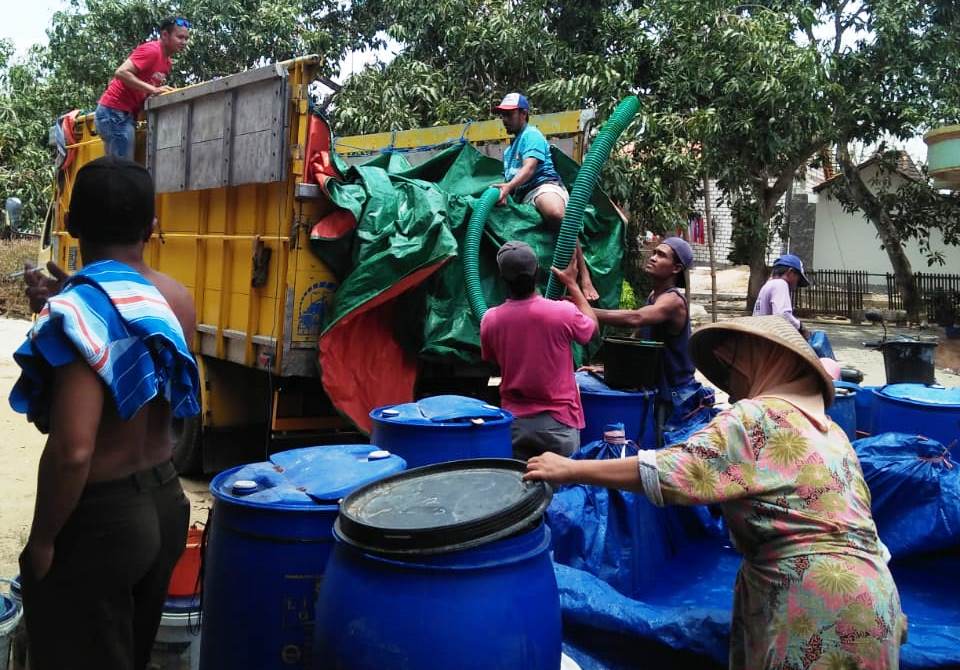 Warga mengerumuni truk berlapis terpal yang membawa bantuan air bersih di Desa Tanjungsekar, Pucakwangi / Foto dari WAG MWC NU Pucakwangi